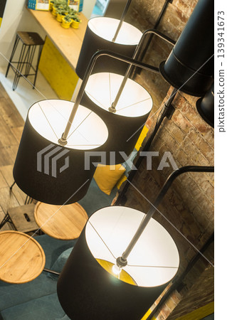 Modern Pendant Lights Over Cozy Seating Area in Contemporary Cafe Interior Scene Modern Pendant Lights Over Cozy Seating Area in Contemporary Cafe Interior Scene 139341673