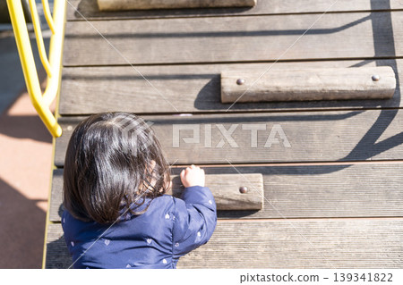 Japanese girl toddler playing on playground equipment in the park 139341822