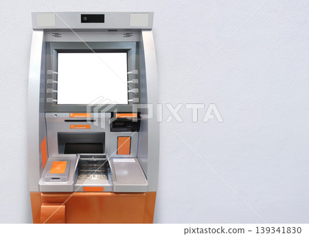 The front view of a silver and orange ATM against a white cement background. The front view of a silver and orange ATM against a white cement background. 139341830