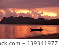 Silhouette of long-tail boat floating in the calm sea with silhouette of mountain and cloudy twilight sky in background 139341977