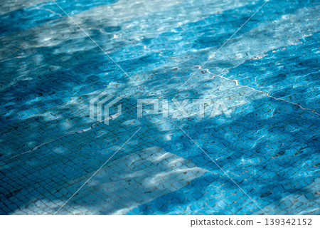 Background image: A pool surface sparkling in the sunlight - blue and light blue. 139342152