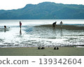 Defocused people walk on the beach with mountain and clear sky in background 139342604