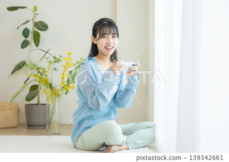 A woman watching a video on her smartphone A woman watching a video on her smartphone 139342661