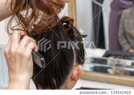 Hair and makeup scene of styling a model's hair Hair and makeup scene of styling a model's hair 139342920
