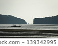Silhouette of long-tail boat floating in the calm sea in front of the space between two islands 139342995