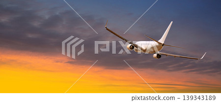 Airplane flying during sunset travel in orange sky 139343189