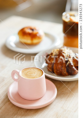hot milk latte coffee and creation black coffee drink and orange juice with croissant on wooden table by the window. hot milk latte coffee and creation black coffee drink and orange juice with croissant on wooden table by the window. 139343273