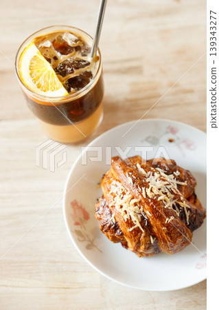 Cup of creation black coffee drink and orange juice with croissant on wooden table by the window. Cup of creation black coffee drink and orange juice with croissant on wooden table by the window. 139343277