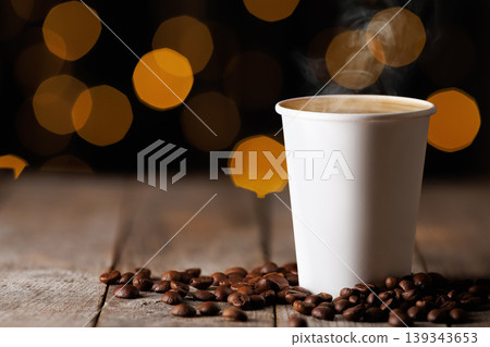 Steaming hot coffee in a white paper cup, surrounded by roasted coffee beans on rustic wooden table with warm bokeh lights creating cozy atmosphere Steaming hot coffee in a white paper cup, surrounded by roasted coffee beans on rustic wooden table with warm bokeh lights creating cozy atmosphere 139343653