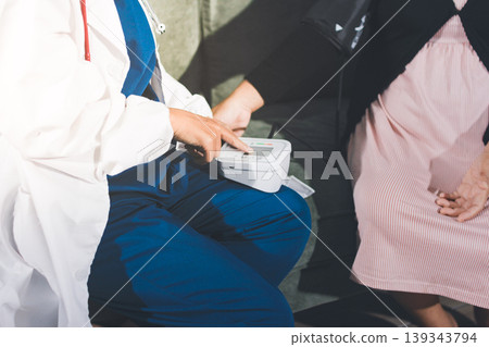 Pregnant woman having her belly examined by a doctor with a stethoscope in a clinic room highlighting a medical checkup, pregnancy health, and prenatal care Pregnant woman having her belly examined by a doctor with a stethoscope in a clinic room highlighting a medical checkup, pregnancy health, and prenatal care 139343794