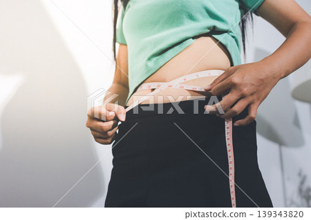 Flabby belly after pregnancy, overweight female body on gray background 139343820