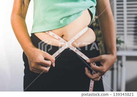Flabby belly after pregnancy, overweight female body on gray background 139343821