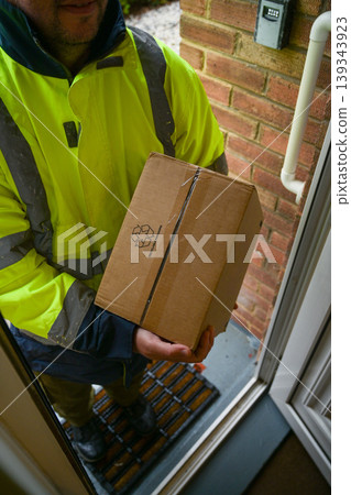 Delivery man at door entrance giving a box to a woman. Online shopping, delivery service Delivery man at door entrance giving a box to a woman. Online shopping, delivery service 139343923