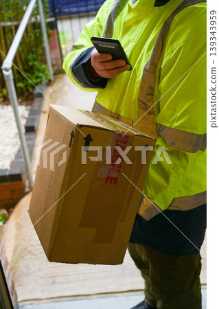 Delivery man at door entrance giving a box to a woman. Online shopping, delivery service Delivery man at door entrance giving a box to a woman. Online shopping, delivery service 139343959