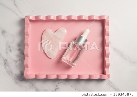 Rose quartz gua sha tool face massage tool and oil bottle, abstract beauty photo 139343973