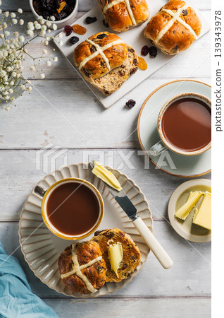 Easter food table setting. Cross Buns with butter, served with tea. Breakfast concept Easter food table setting. Cross Buns with butter, served with tea. Breakfast concept 139343978