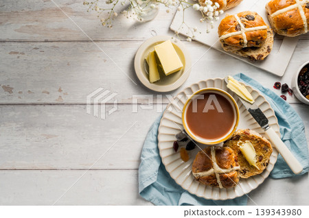 Cross Buns with butter in a plate. Breakfast concept. Top view. Easter treat buns with copy space Cross Buns with butter in a plate. Breakfast concept. Top view. Easter treat buns with copy space 139343980