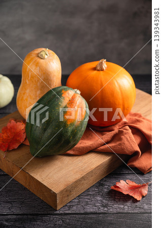 Orange, green and white squashes, dark moody background, autumn concept Orange, green and white squashes, dark moody background, autumn concept 139343981