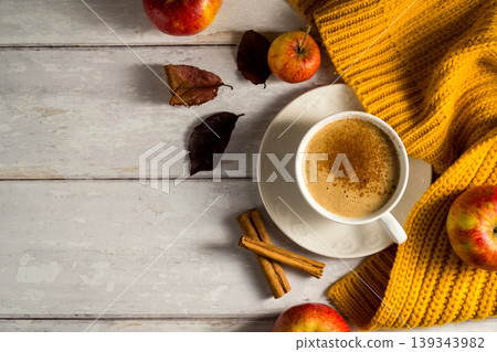 Cosy autumn coffee drink, with apples and cinnamon, orange pumpkins, wooden rustic background 139343982