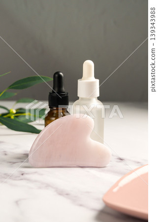 Rose quartz gua sha and oil bottles, abstract beauty photo Rose quartz gua sha and oil bottles, abstract beauty photo 139343988