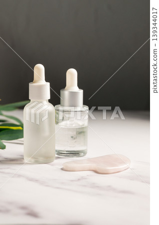 Rose quartz gua sha and oil bottles, abstract beauty photo Rose quartz gua sha and oil bottles, abstract beauty photo 139344017