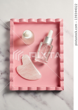 Rose quartz gua sha tool face massage tool and oil bottle, abstract beauty photo Rose quartz gua sha tool face massage tool and oil bottle, abstract beauty photo 139344022