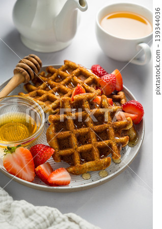 Belgian waffles with strawberries, cup of tea and fresh fruits. Homemade breakfast food Belgian waffles with strawberries, cup of tea and fresh fruits. Homemade breakfast food 139344036