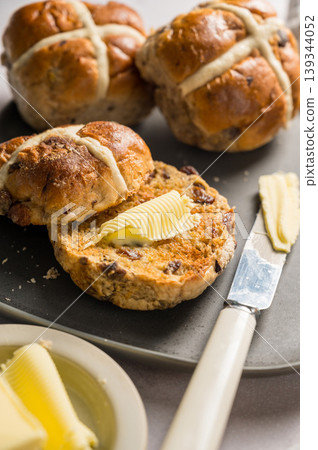 Cross Buns with butter in a plate. Breakfast concept. Close up shot. Easter treat buns Cross Buns with butter in a plate. Breakfast concept. Close up shot. Easter treat buns 139344052