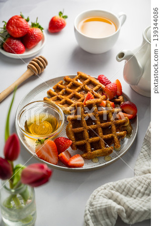 Belgian waffles with strawberries, cup of tea and fresh fruits. Homemade breakfast food 139344086