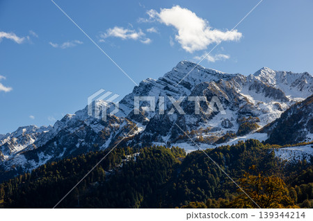 Snow-covered mountains stand tall under a clear sky in a remote location Snow-covered mountains stand tall under a clear sky in a remote location 139344214