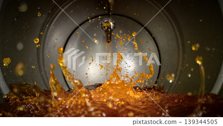 Gasoline jet pouring into metal fuel tank, inside view with dynamic splash and turbulence. Concept of refueling, fuel storage and energy supply, industrial environment. 139344505
