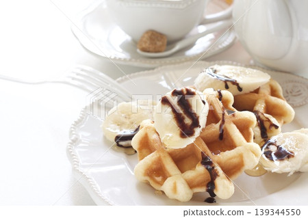 Belgian waffles topped with bananas Belgian waffles topped with bananas 139344550