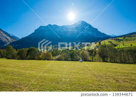 Autumn pastures in Grindelwald, with white hay bales and the Eiger mountain in the background. Grindelwald, Bern Canton, Switzerland Autumn pastures in Grindelwald, with white hay bales and the Eiger mountain in the background. Grindelwald, Bern Canton, Switzerland 139344671