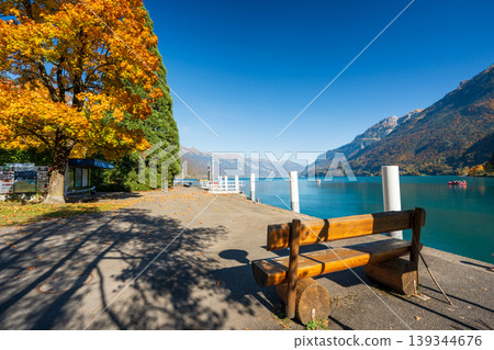 Autumn scenery on the shores of Lake Brienz with a wooden bench by the water. Benningen, Canton of Bern, Switzerland Autumn scenery on the shores of Lake Brienz with a wooden bench by the water. Benningen, Canton of Bern, Switzerland 139344676