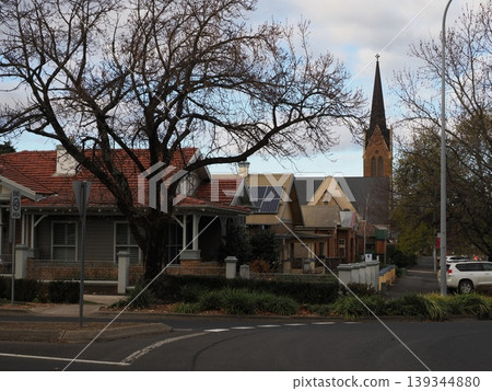 A cathedral spire peeking out from a residential area—a landscape of faith thriving in a quiet life. A cathedral spire peeking out from a residential area—a landscape of faith thriving in a quiet life. 139344880