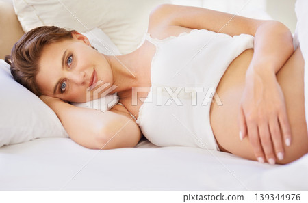 Pregnant woman, love stomach and portrait on bed with relax wellness and mindfulness for prenatal care. Person, smile face and connect for pregnancy gratitude, rest and maternity touch in apartment Pregnant woman, love stomach and portrait on bed with relax wellness and mindfulness for prenatal care. Person, smile face and connect for pregnancy gratitude, rest and maternity touch in apartment 139344976