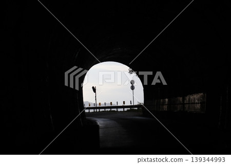 A landscape where a bright exit can be seen at the end of a dark tunnel. 139344993