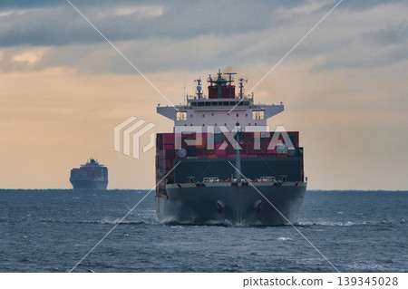 A container ship sailing the sea at dusk. A container ship sailing the sea at dusk. 139345028