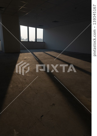 Office spaces with large windows and city views, featuring patterns of shadows cast by natural light. Office spaces with large windows and city views, featuring patterns of shadows cast by natural light. 139345167