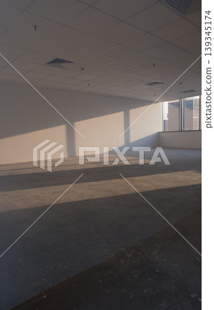 Office spaces with large windows and city views, featuring patterns of shadows cast by natural light. Office spaces with large windows and city views, featuring patterns of shadows cast by natural light. 139345174