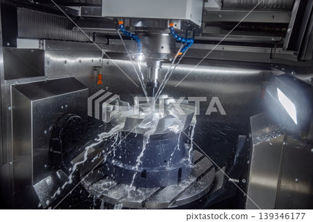 CNC milling machine machining metal turbine part with coolant spray. CNC milling machine machining metal turbine part with coolant spray. 139346177