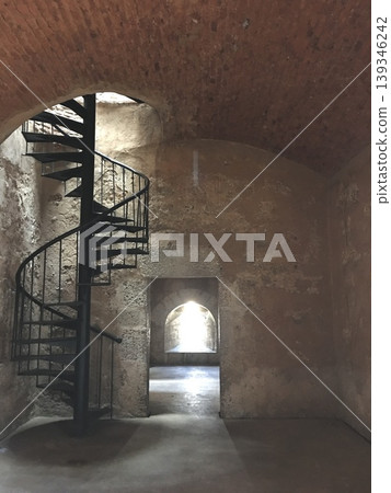 Spiral staircase in historic stone interior with soft natural light, clean architectural background Spiral staircase in historic stone interior with soft natural light, clean architectural background 139346242