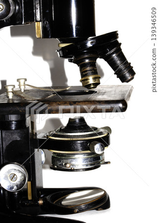 A used vintage microscope from the army on white background 139346509
