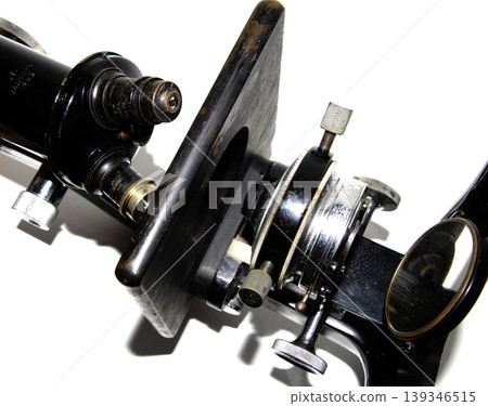 A used vintage microscope from the army on white background A used vintage microscope from the army on white background 139346515
