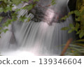 A small waterfall in a stream bathed in sunlight 139346604