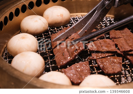 特寫:牛肉片和肉鉗在炭火上烤製。 特寫:牛肉片和肉鉗在炭火上烤製。 139346608