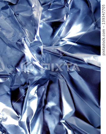 Shiny crumpled abstract silver foil close up background Shiny crumpled abstract silver foil close up background 139347705