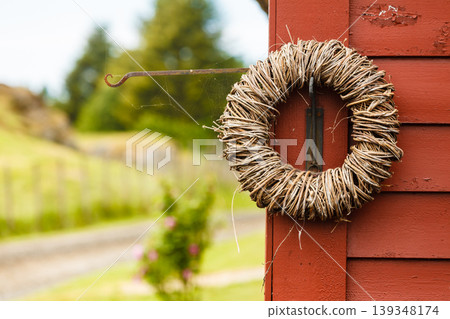 Rounded wicker decoration hanging on wooden wall Rounded wicker decoration hanging on wooden wall 139348174
