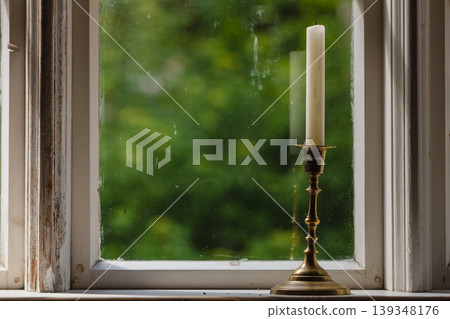 Old vintage window and vertical candle in candlestick Old vintage window and vertical candle in candlestick 139348176