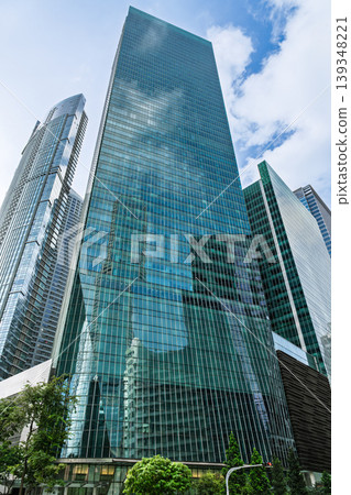 Tall glass office tower with reflective facade in city Tall glass office tower with reflective facade in city 139348221